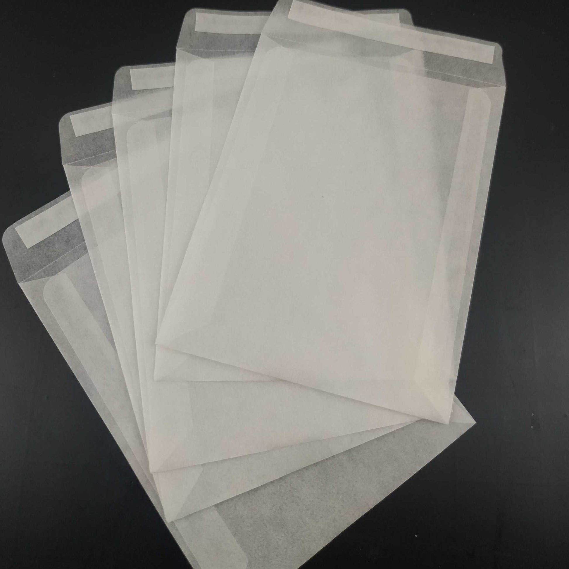 Assorted sizes of eco-friendly glassine peel and seal envelopes, showcasing small and large options for sustainable, biodegradable packaging solutions