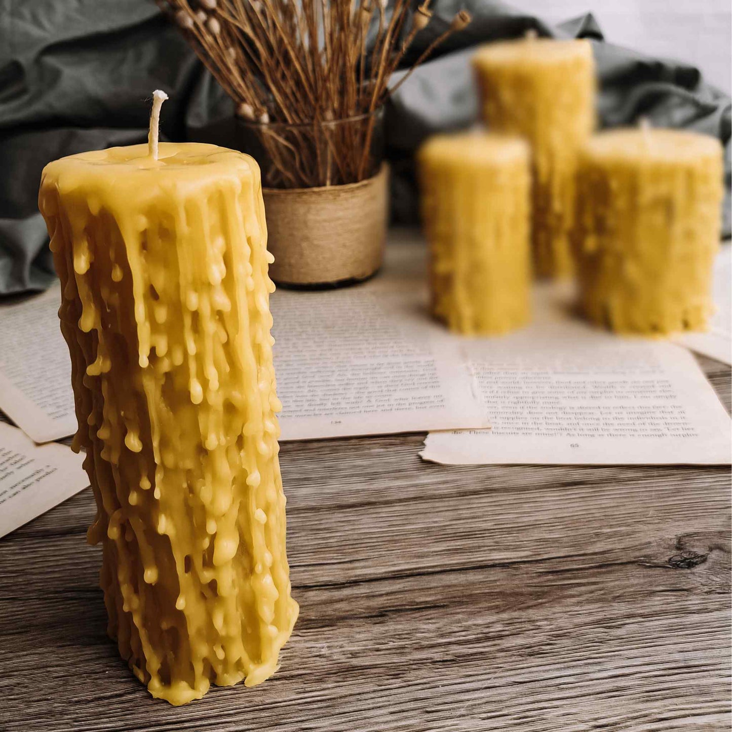 Elegant beeswax drip candles made from British beeswax, arranged on a vintage wooden table, enhancing a gothic decor