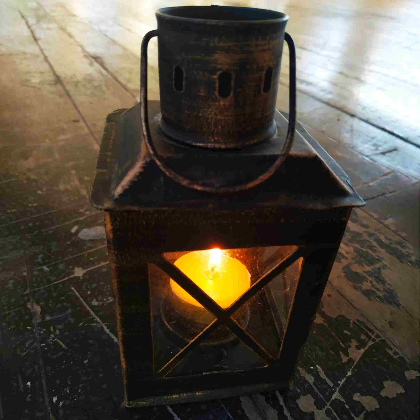 Aged metallic lantern with a flickering candlelight, casting a warm glow through its glass window, set against an antique wooden backdrop