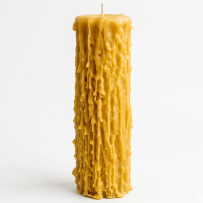 An extreme macro close-up photograph capturing the intense, cascading, organic textures of a lit beeswax candle. The deep golden-yellow drips are highly detailed, leading up to a bright flame and the central cotton wick against a blurred, dark background.